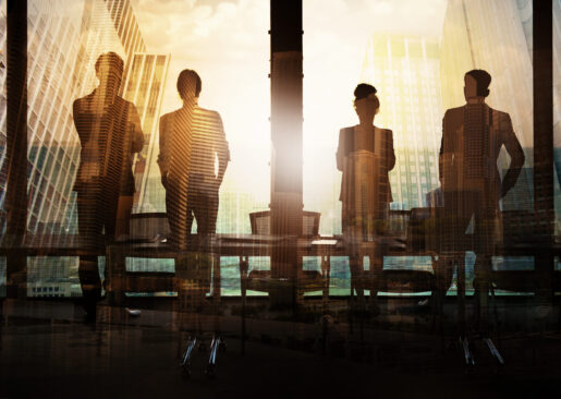Four individuals standing next to each lit by sunlight in the background.