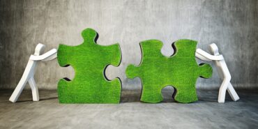 Two puzzle pieces being pushed together by cartoon figures.