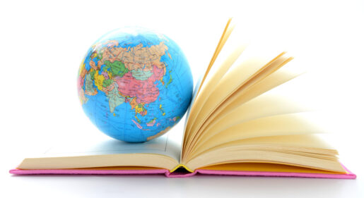 Image of a book propped open with a globe.