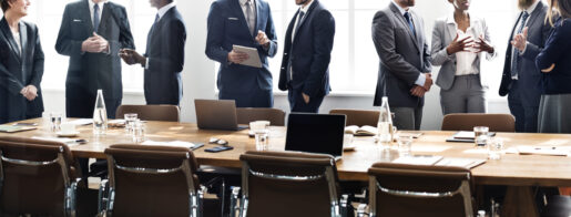 Image of individuals standing around a conference room table.