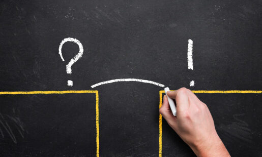 A hand illustrates how you get from point A to point B on a chalkboard, with a line drawn between a question mark and an exclamation point.
