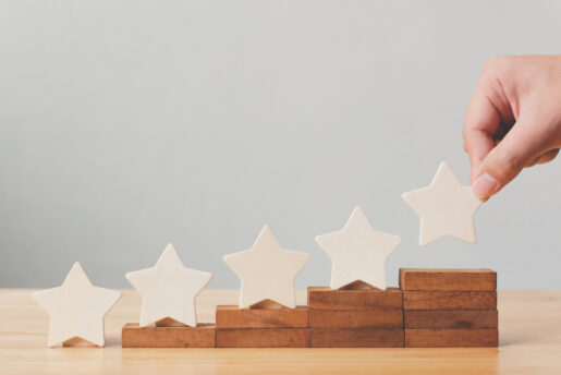 A hand places a fifth star on small risers.