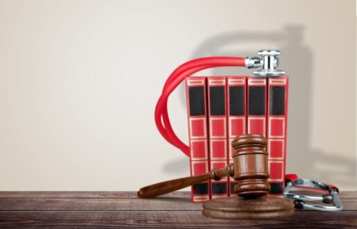A gavel sits in front of business books with a stethoscope