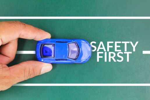 A hand holds a car on a road that says 